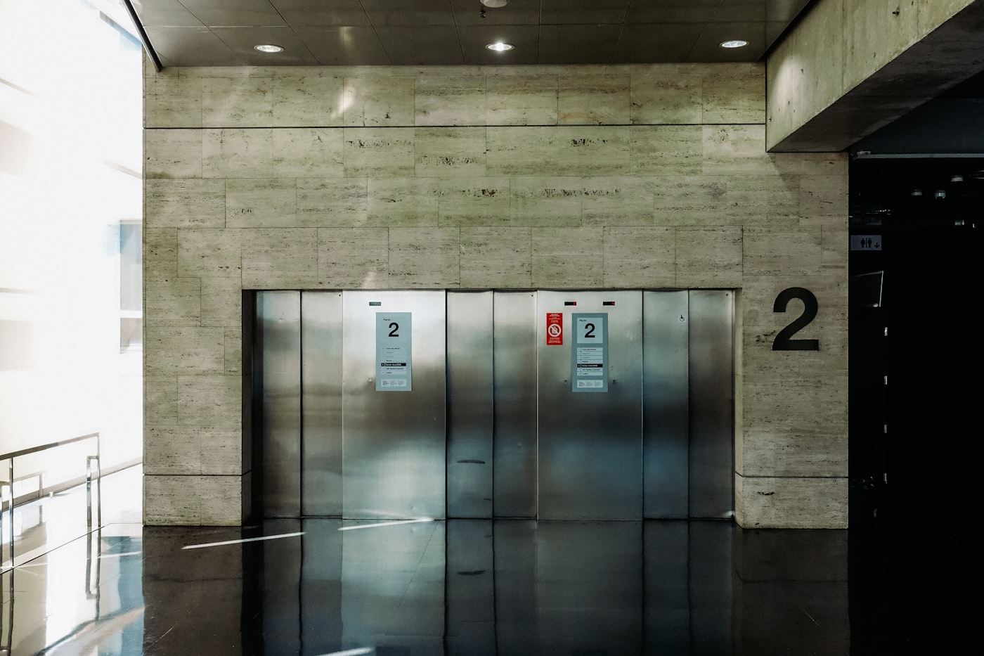 Stainless elevator doors inside a building lobby — varnish mitigation