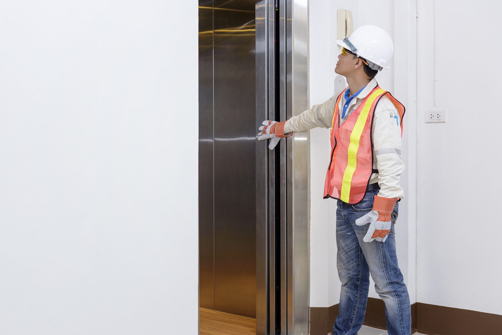 Service technician inspecting an interior hydraulic elevator