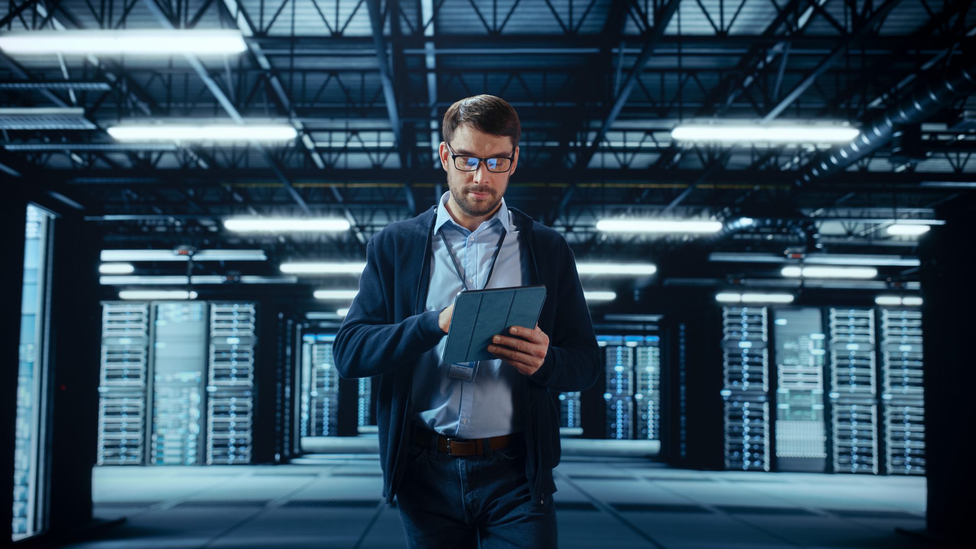 IT engineer monitoring systems on a tablet in a data center