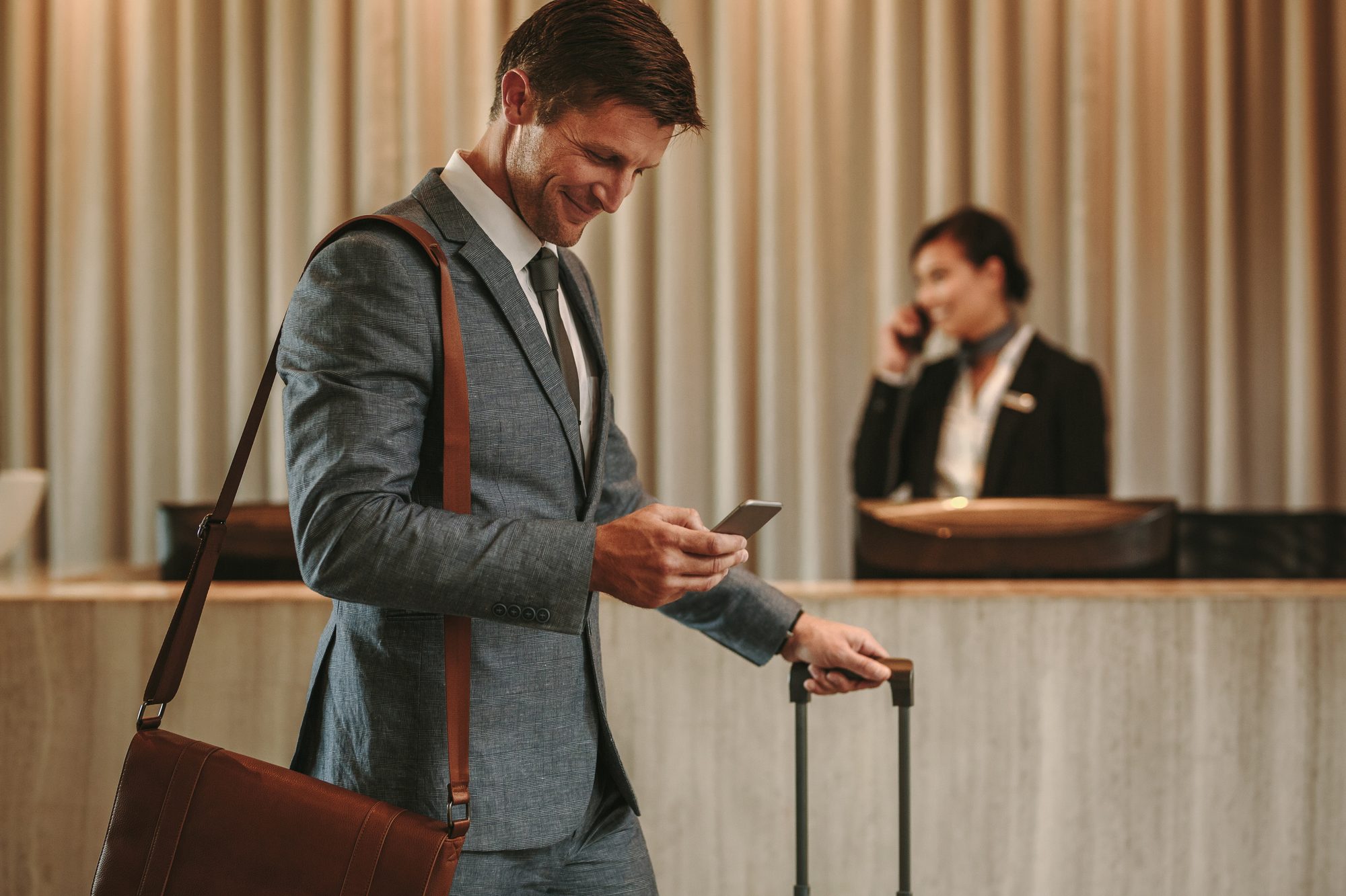 Hotel guest on phone at check-in